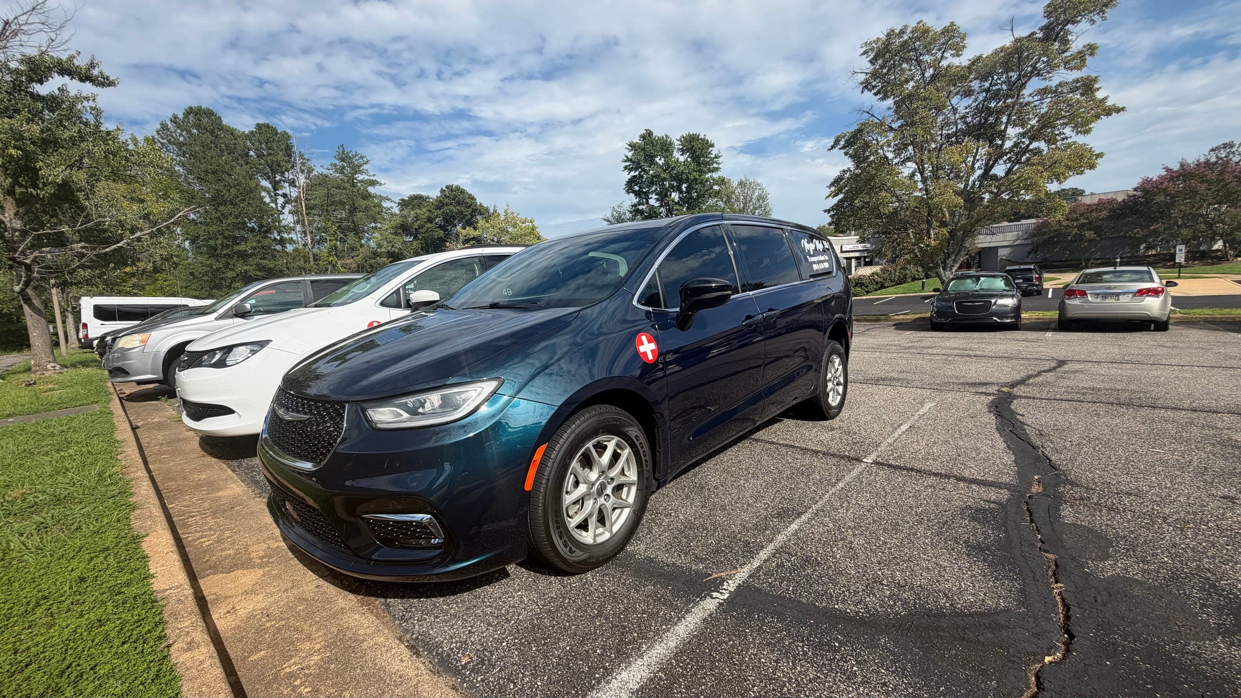 Dark blue Virgin Med minivan at the head of a row of fleet vehicles